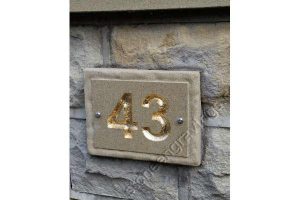Customer Photo. This Yorkstone number sign was supplied by us with th numbers left natural, The customer Gilded the numbers with gold leaf. And what a great job! The font Arial bold.