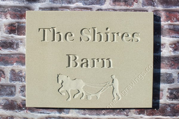The Shires Barn. York stone house sign with Ploughman and horse motif. The font is "Times Roman Bold".